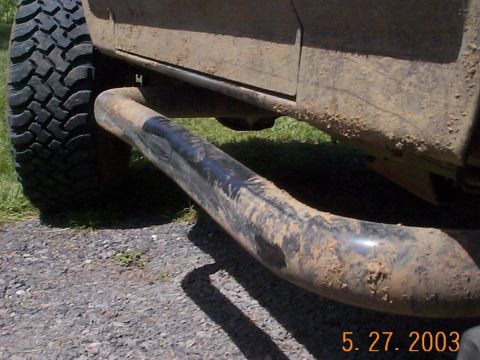 1983 Ford Bronco - A dirty SUV's side panel and brush guard are visible, along with a large tire.