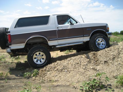 1993 Ford Bronco - This 1993 Ford Bronco is shown off-roading on a dirt hill with a two-tone paint scheme.