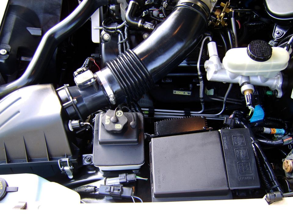 Engine bay with black intake tube, air box, and brake fluid reservoir