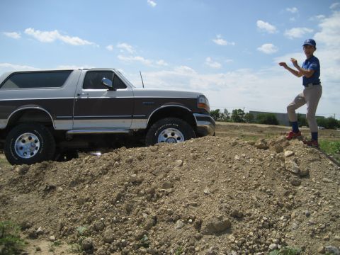 1993 Ford Bronco - This lifted 1993 Ford Bronco is shown in a side profile, equipped with off-road tires, navigating a dirt mound.