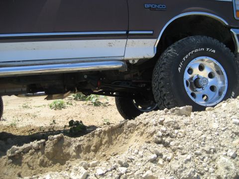 1993 Ford Bronco - 1993 Ford Bronco with lift kit and all-terrain tires navigating rough terrain.