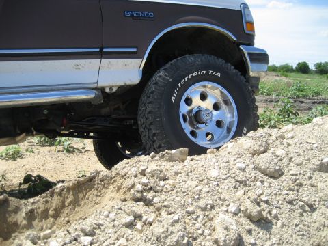1993 Ford Bronco - This 1993 Ford Bronco is shown navigating a rough, dirt terrain with its off-road tires and lifted suspension.