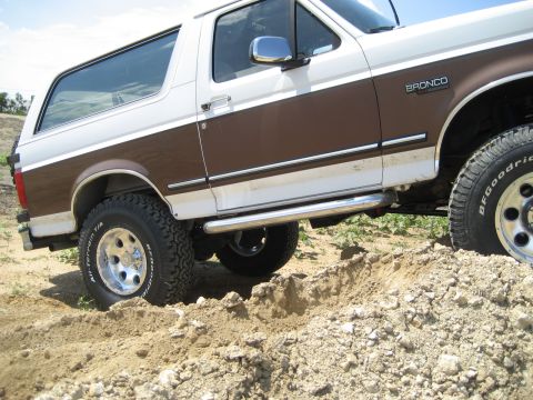 1993 Ford Bronco - This 1993 Ford Bronco is shown navigating a dirt track with its tires on uneven terrain.