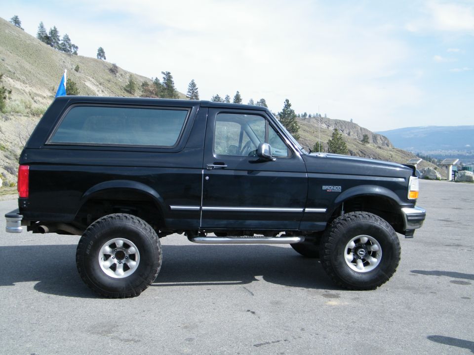 Black 1996 Ford Bronco, lifted, side view, with chrome trim and aftermarket wheels