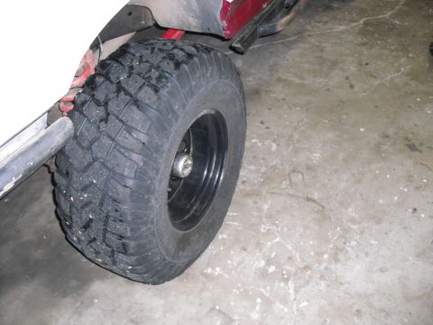 1991 Ford Bronco - A close-up view of a vehicle's tire and wheel assembly.