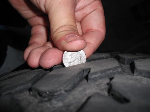 1991 Ford Bronco - Checking tire tread depth with a coin.