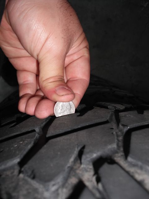 1991 Ford Bronco - Checking tire tread depth with a coin.