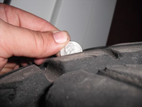 1991 Ford Bronco - Checking tire tread depth with a coin.