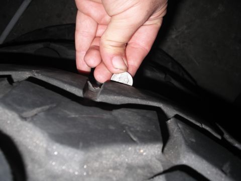 1991 Ford Bronco - A dime is used to measure the tread depth of a tire, indicating wear.