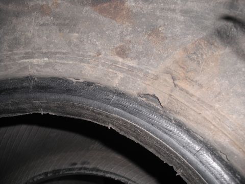 1991 Ford Bronco - This tire shows significant wear and damage, with exposed cords visible on the sidewall.