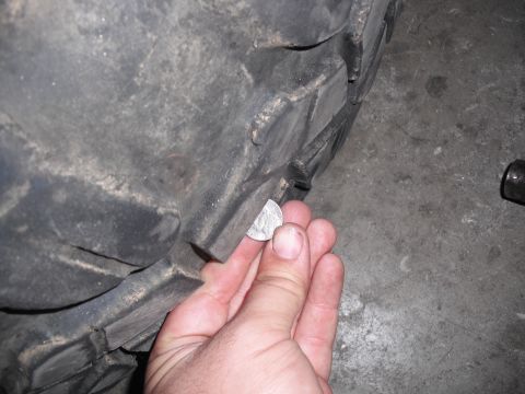 1991 Ford Bronco - A hand uses a quarter to check the tread depth of a tire, indicating wear.
