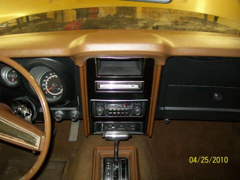 1972 Ford Mustang - The interior of a car shows the dashboard, steering wheel, and center console with radio and shifter.