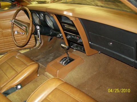 1972 Ford Mustang - The interior of a 1971 Ford Mustang features tan upholstery and a wood-grain dashboard trim.