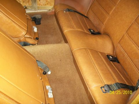 1972 Ford Mustang - The interior of a 1972 Ford Mustang features tan vinyl seats with seat belts and brown carpeting.