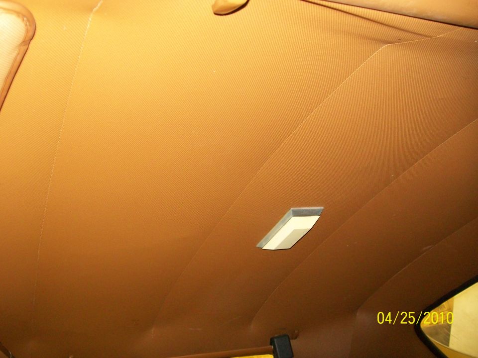 Car interior headliner with a textured pattern and a rectangular dome light. Date stamp reads 04/25/2010