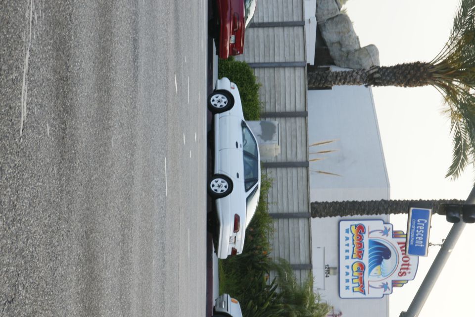 White sedan parked, side view. Visible text includes 'Knott's Soak City Water Park'
