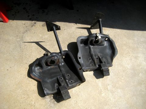 1996 Ford Bronco - Two black front suspension components are laid out on a concrete surface, casting shadows.