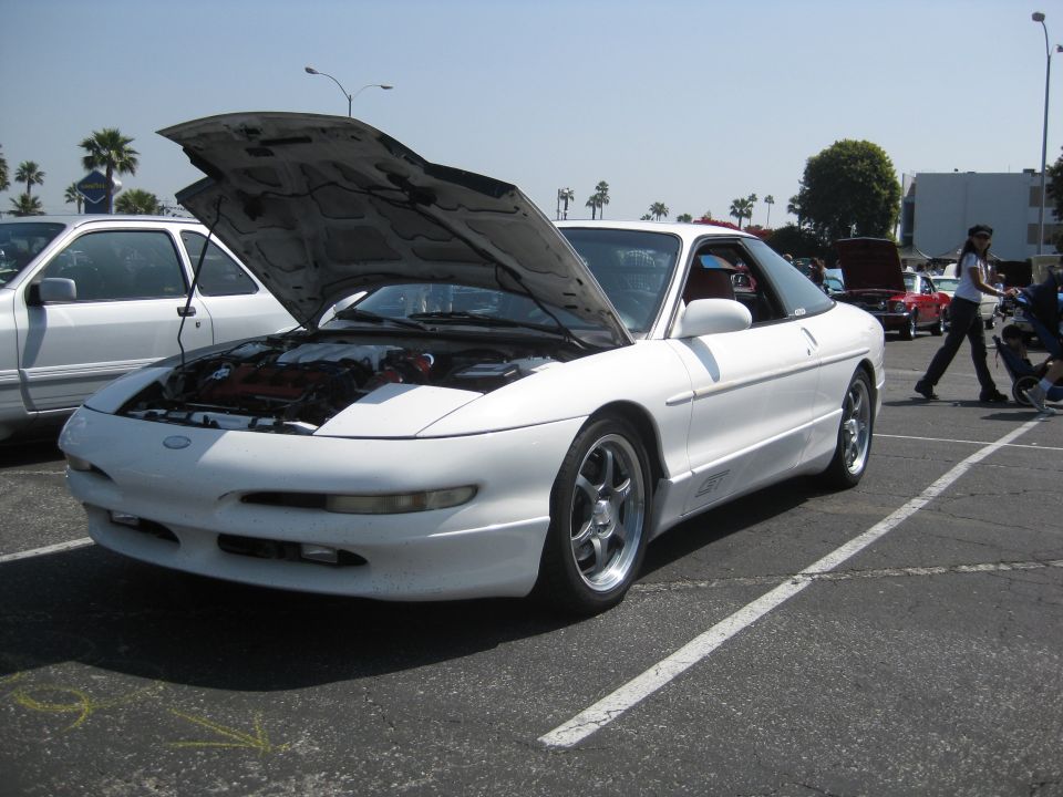 White 1990 Ford Probe with hood open, parked in a lot next to another car