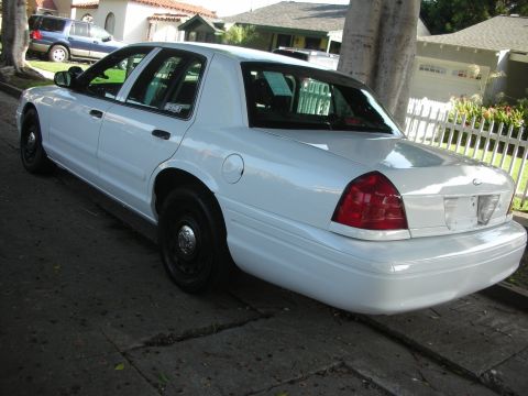 2004 Ford Crown Victoria - Rear view of a white 2004 Ford Crown Victoria sedan parked curbside on a residential street.