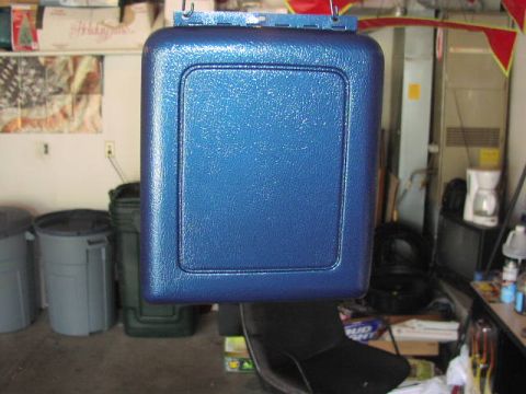 1981 Ford Bronco - A blue painted part with a recessed panel hangs in a garage setting.