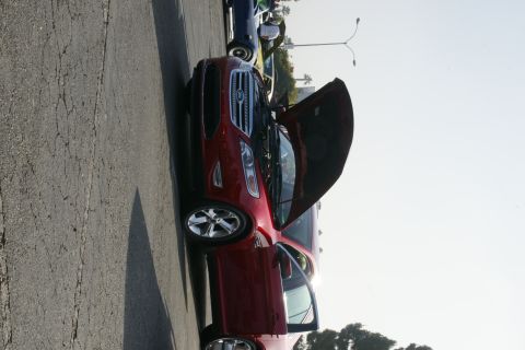 1992 Ford Taurus - A red Ford sedan is parked with its hood and driver's door open, showing another vehicle behind it.