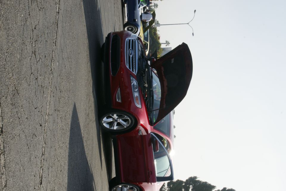 Red Ford sedan, hood and door open, 3/4 front view