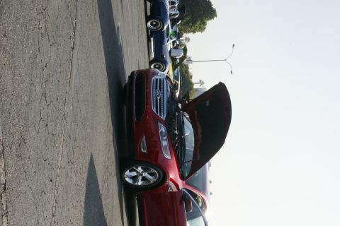 1992 Ford Taurus - A red Ford sedan with its hood open is parked next to other vehicles on a sunny day.