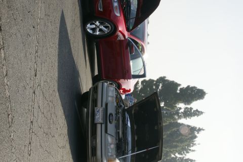 1992 Ford Taurus - Two Ford sedans are parked side-by-side, one with its hood open, revealing the engine compartment.