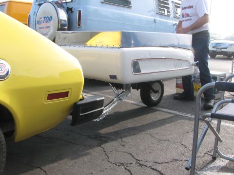 1996 Ford C-350 (Centurion Conversions) - Yellow car towing a small white trailer, with a blue stripe and chrome accents.