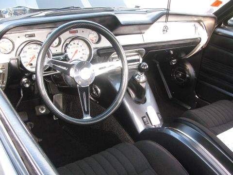 1996 Ford C-350 (Centurion Conversions) - Custom interior with aftermarket gauges and a chrome steering wheel. The dashboard is black.