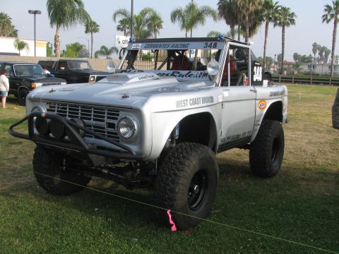 1996 Ford C-350 (Centurion Conversions) - Modified silver Ford Bronco with off-road tires and roll cage is displayed on grass.