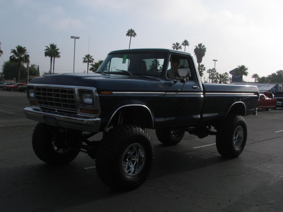 Dark blue lifted pickup truck, 3/4 front view. Likely a 1979 Ford F-Series