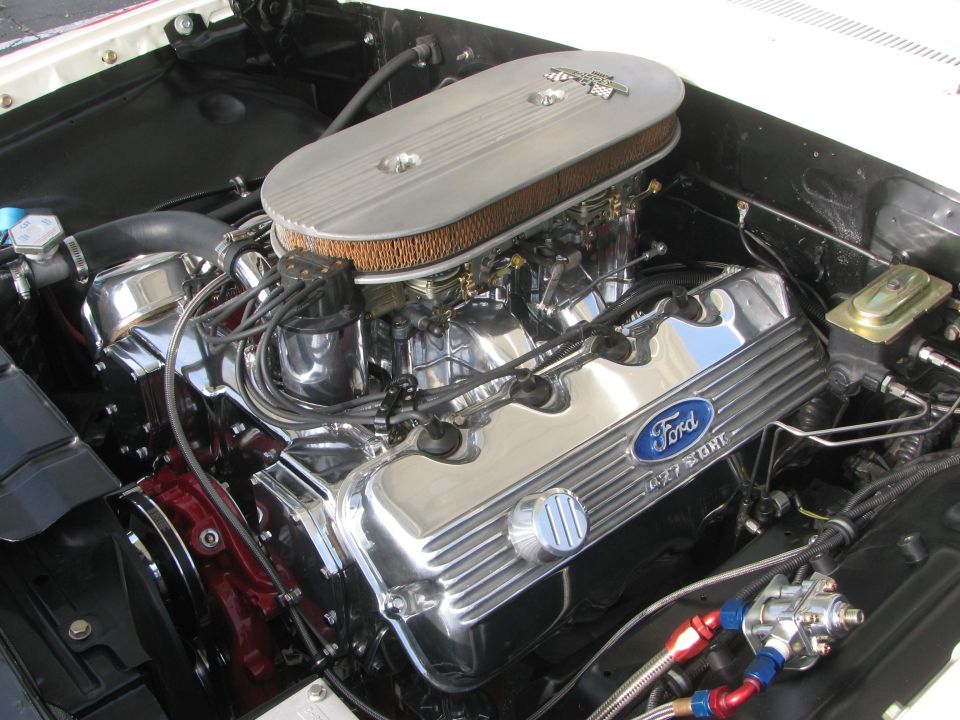Close-up of a Ford V8 engine with chrome valve covers and an oval air cleaner