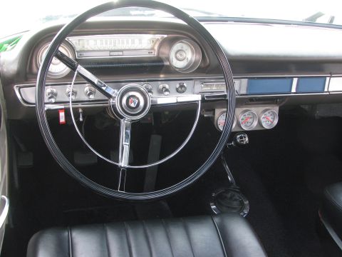 1996 Ford C-350 (Centurion Conversions) - Interior view of a classic car, showing the dashboard, steering wheel, and seats. The dashboard has multiple gauges.
