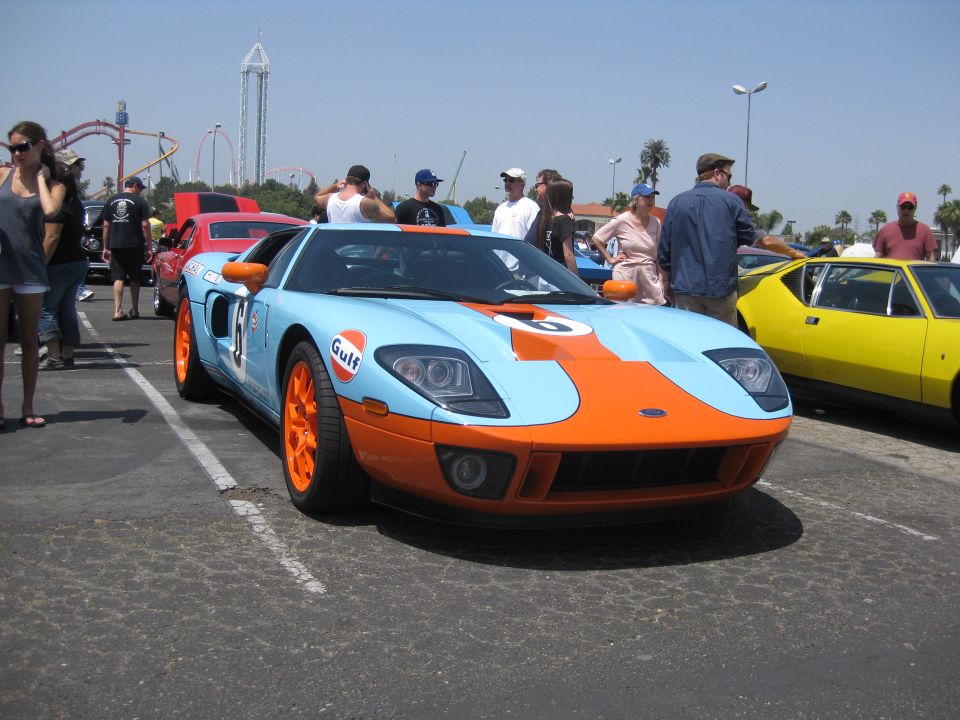 Light blue and orange Gulf livery race car, front 3/4 view, parked outdoors