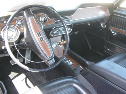 1996 Ford C-350 (Centurion Conversions) - The interior of this classic Mustang features woodgrain accents on the dashboard and steering wheel, along with Shelby Cobra badging on the…