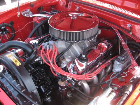 1996 Ford C-350 (Centurion Conversions) - Close-up view of a V8 engine bay a large chrome air filter and red spark plug wires.