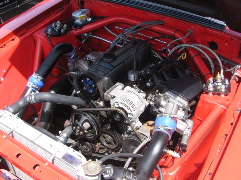 1996 Ford C-350 (Centurion Conversions) - The engine bay features a turbocharged engine with various aftermarket modifications and red painted components.