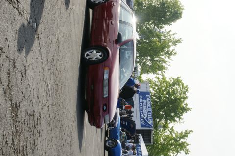 1992 Ford Taurus - A maroon 1992 Ford Taurus is parked at an outdoor event with a banner in the background.