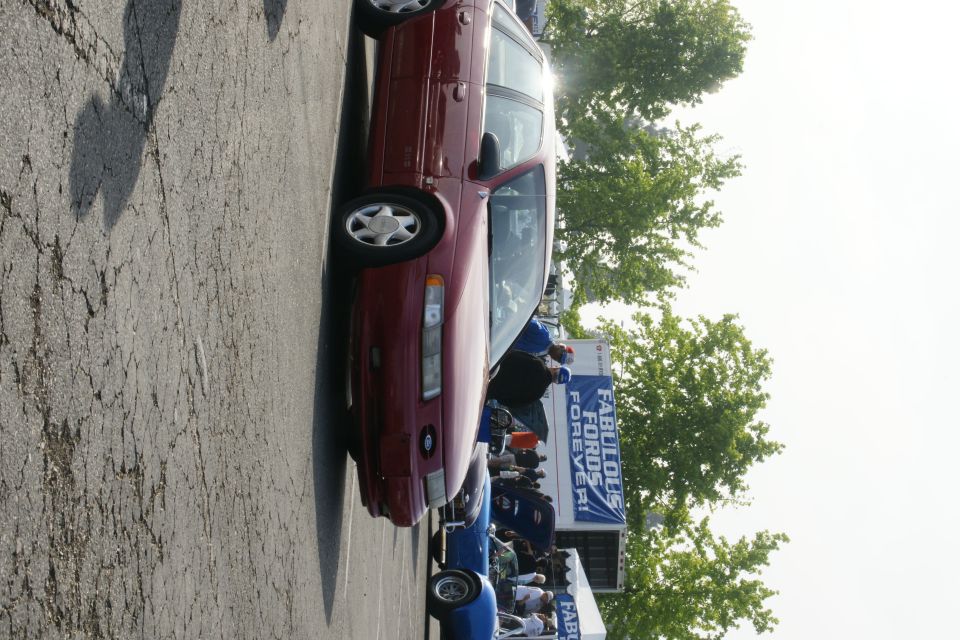 Maroon 1992 Ford Taurus sedan parked on asphalt, seen from the front quarter angle