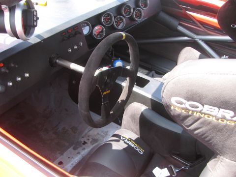 1996 Ford C-350 (Centurion Conversions) - The interior of a race car features Cobra Technology seats and a Momo steering wheel, with multiple gauges on the dashboard.