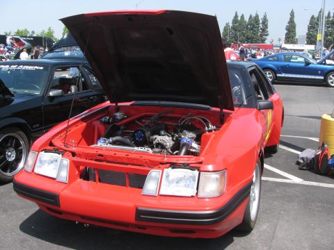 1996 Ford C-350 (Centurion Conversions) - Red car with hood open, revealing the engine bay. Other vehicles are visible in the background.