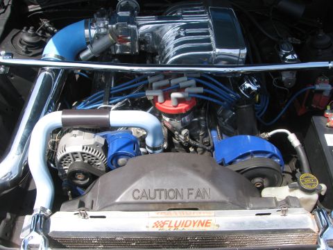 1996 Ford C-350 (Centurion Conversions) - Engine bay features a chrome supercharger, blue hoses, and a 'CAUTION FAN' shroud. The Fluidyne label is also visible.
