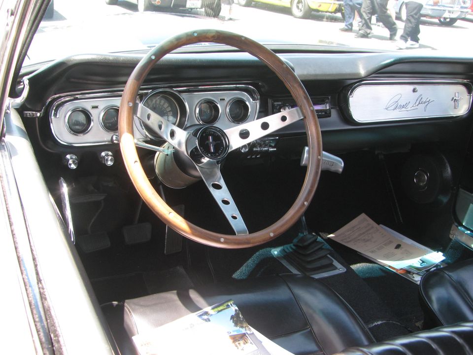 1965 Ford Mustang interior with wood-rimmed steering wheel and Shelby signature dash plaque