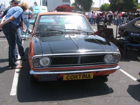 1996 Ford C-350 (Centurion Conversions) - This two-tone Ford Cortina is displayed at an outdoor event with spectators around.