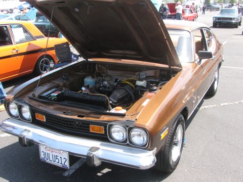 1996 Ford C-350 (Centurion Conversions) - Brown Ford Capri with hood open, displaying its engine and a California license plate.