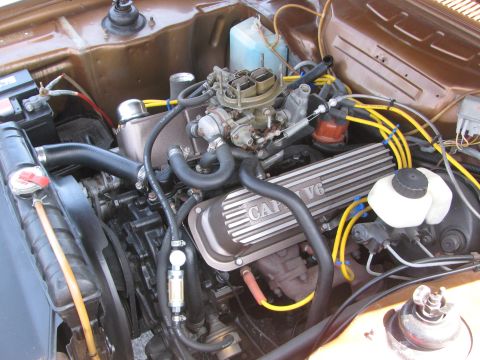 1996 Ford C-350 (Centurion Conversions) - Close-up of a Capri V6 engine bay, showing the carburetor, valve covers, and wiring.