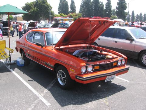 1996 Ford C-350 (Centurion Conversions) - Orange coupe with hood open at a car show, parked next to another vehicle.