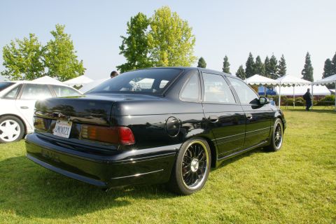 1992 Ford Taurus - Black 1992 Ford Taurus with custom wheels at an outdoor car show.