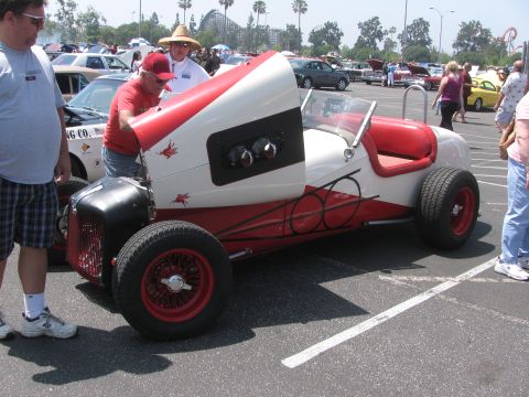 1996 Ford C-350 (Centurion Conversions) - A custom hot rod with a unique red and white paint scheme is displayed at an outdoor event.